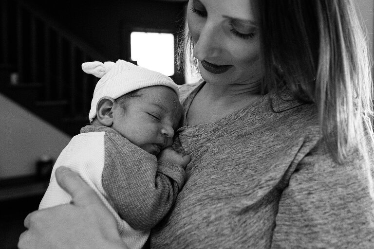 Black and white. Mom holds sleeping baby. 