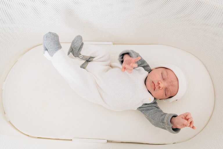 Newborn sleeps in bassinet 