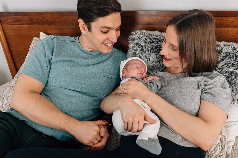 Mom and Dad smile at their newborn baby