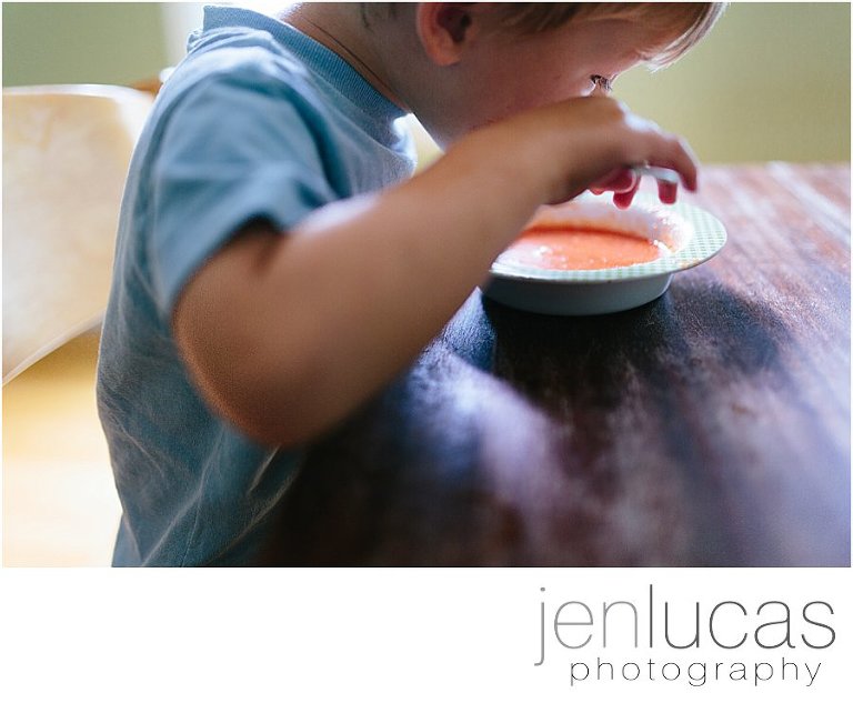 Boys eats tomato soup at dining room table 
