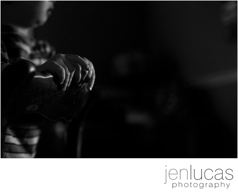 Black and white. Light hits toddler hands, only illuminating the highlights 