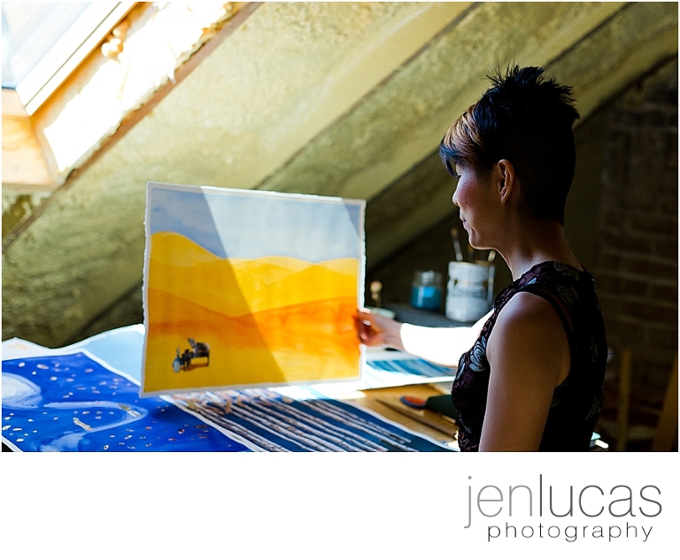 Soyoung Kim holding up a piece of her work. 