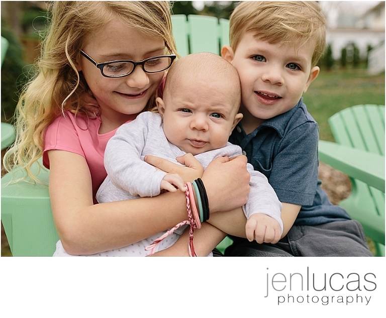 Three siblings squeeze together for a family picture. 