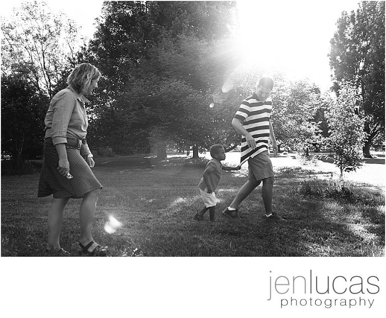 Black and white. Family of three walk through the gardens. 
