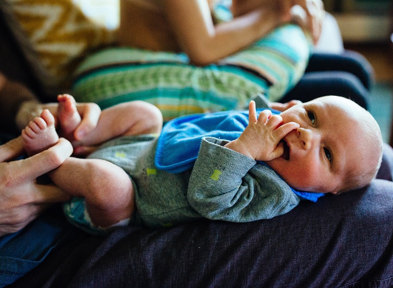 Newborn baby laid down on fathers lap.