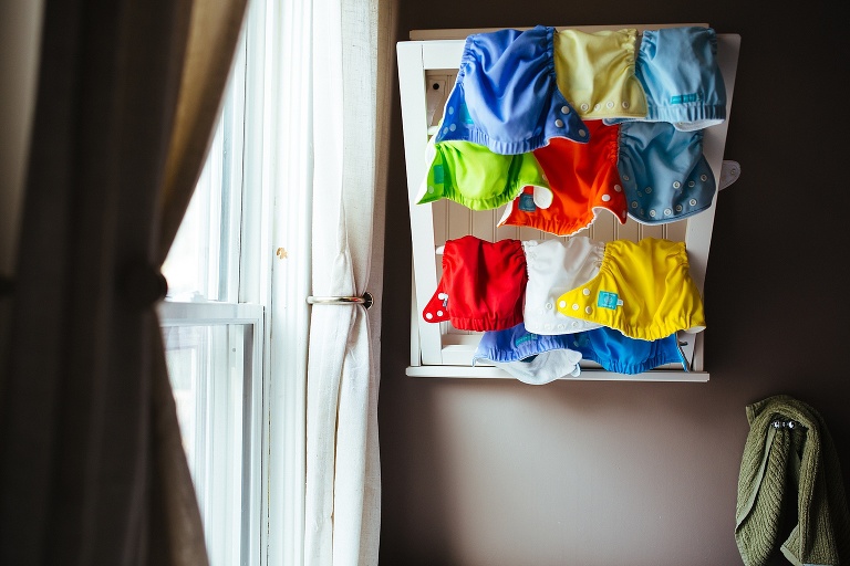 reusable dipers hung on drying rack on the wall.