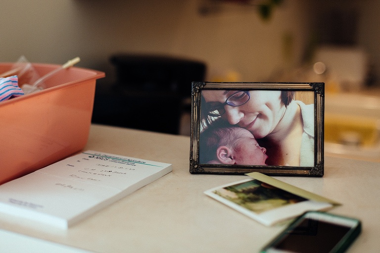 Table with a pad of paper, phone, and image of mother with her newborn baby.