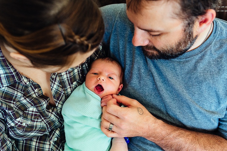 Mother and father hold and look at their newborn baby girl.