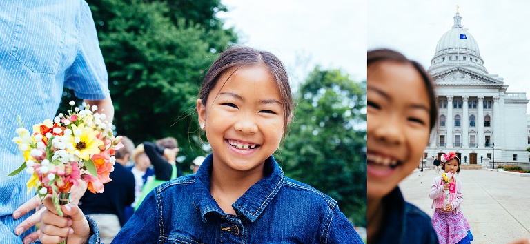 Girl smiles while holding a bouquet of flowers.