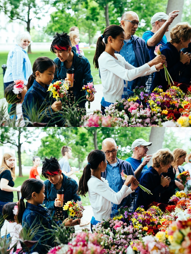 Family at a farmers market pick out a bouquet of flowers.