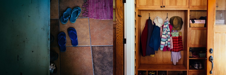 Flip flops sitting on the floor. coats hung up on the wall.