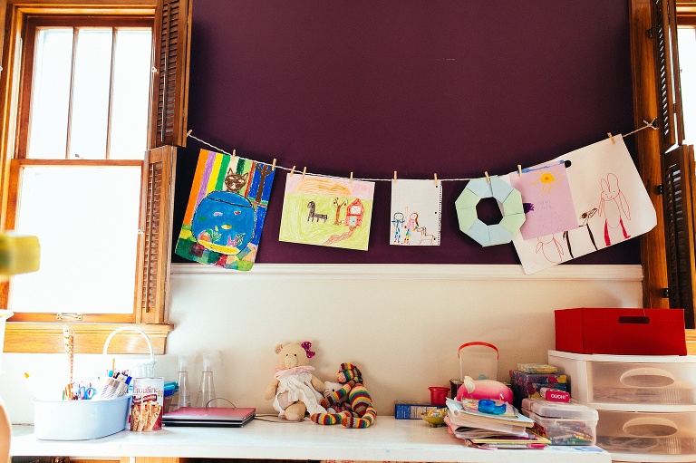 Art hung up on the wall of a playroom.