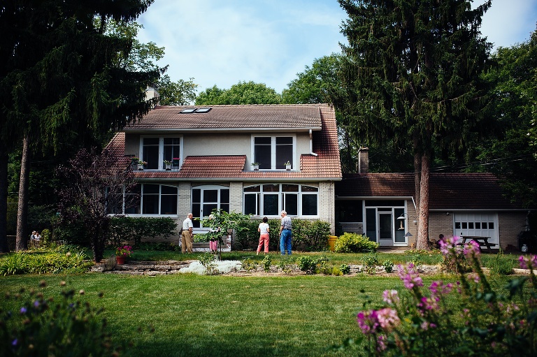 Family standing together outside in the backyard of their old house.
