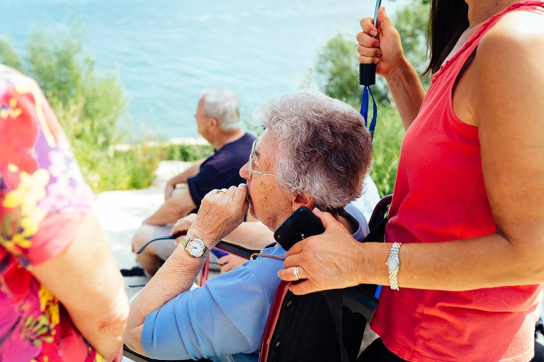 Family standing around a lake. 90 year old mother/grandmother celebrates her birthday.