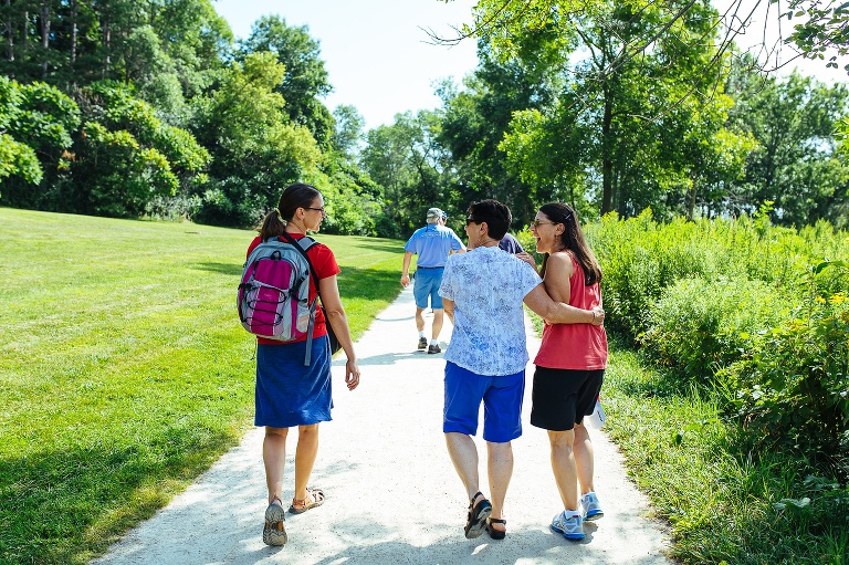 3 generations of family walks down a lakeshore path.