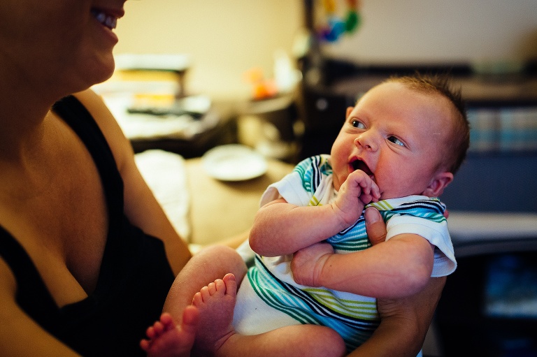 Mom holds up newborn baby.