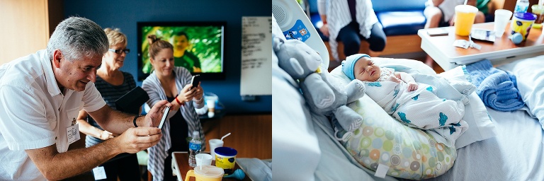 Family stands around taking photos of sleeping newborn baby.