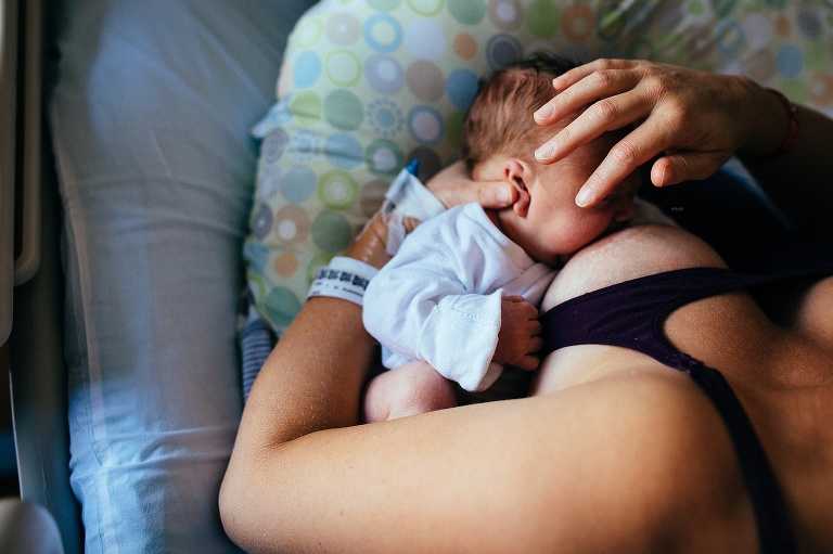 Mom in the hospital breastfeeding newborn baby.