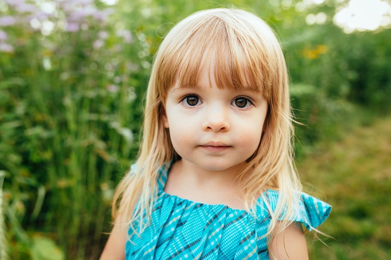 Young girl standing outside looks at the camera.