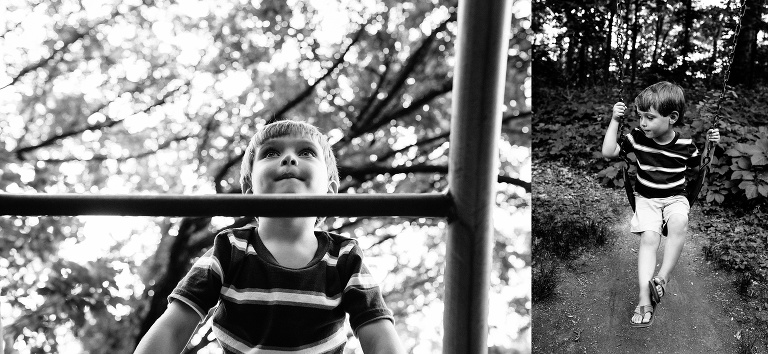 Black and white. Young boy outside sitting on a swing and climbing up a ladder at a playground.