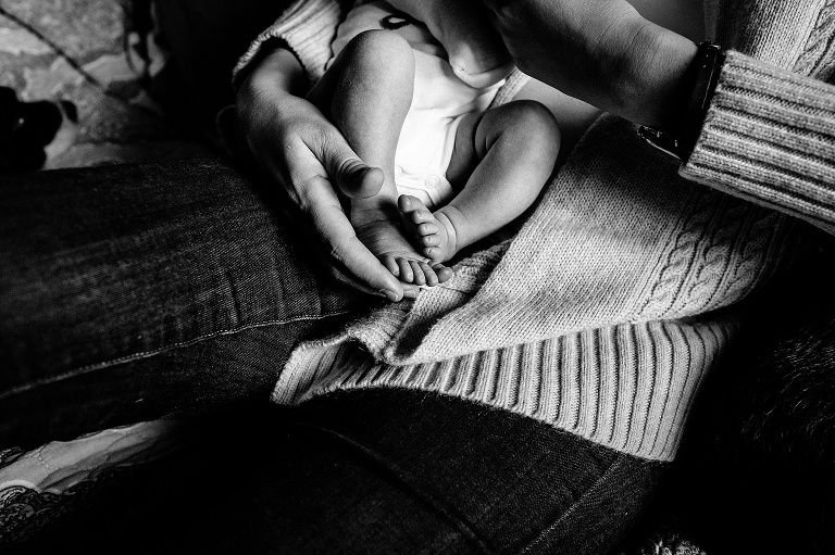 Blacka and white. Mother holds newborn baby's tiny feet.