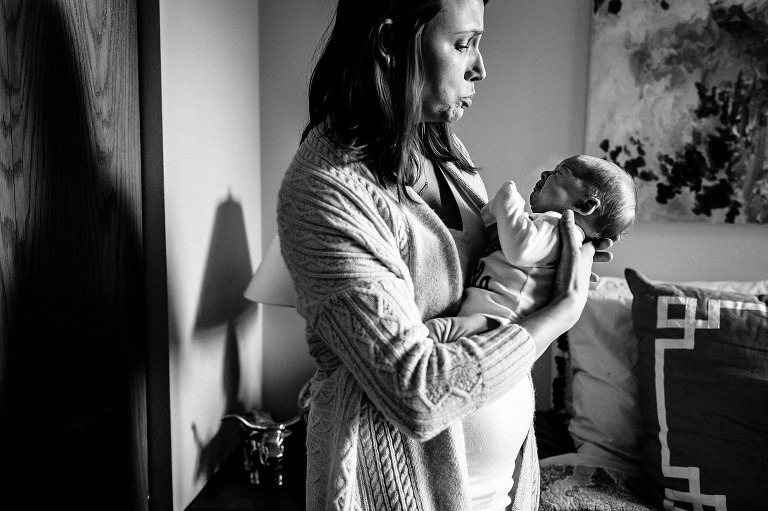 Black and white. Mother holds and comforts crying newborn baby.