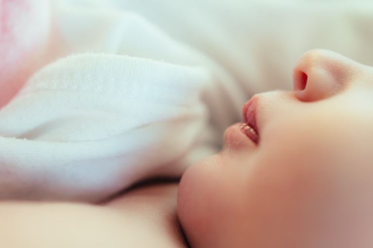 Newborn baby girls little nose and pink lips.