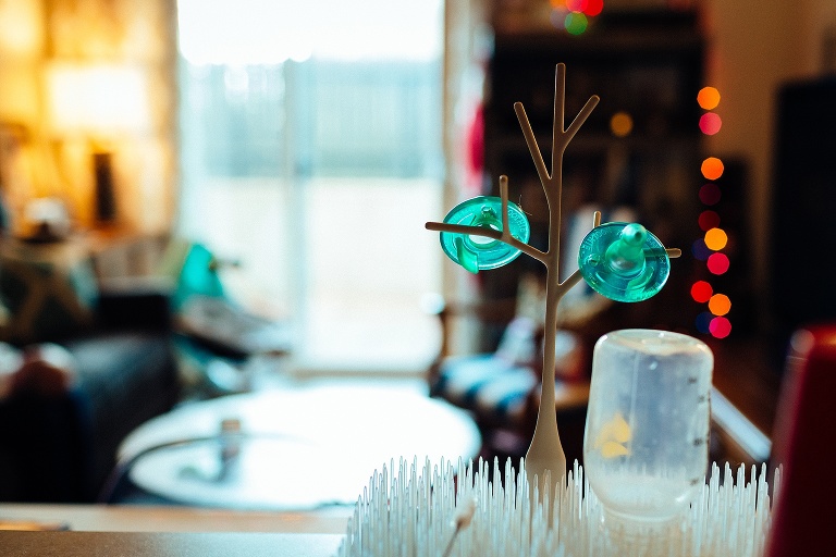 Baby bottle on drying rack sitting on kitchen counter.