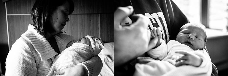 Black and white. Mother and father hold swaddled newborn baby in the hospital.