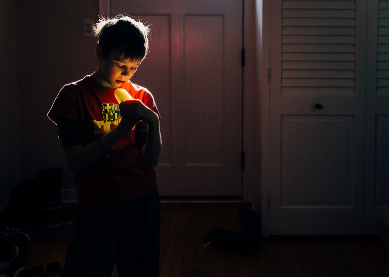Boy looks at Popsicle that is glowing in the light