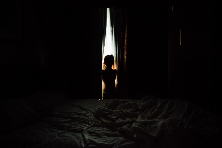 Child looks out hotel curtains