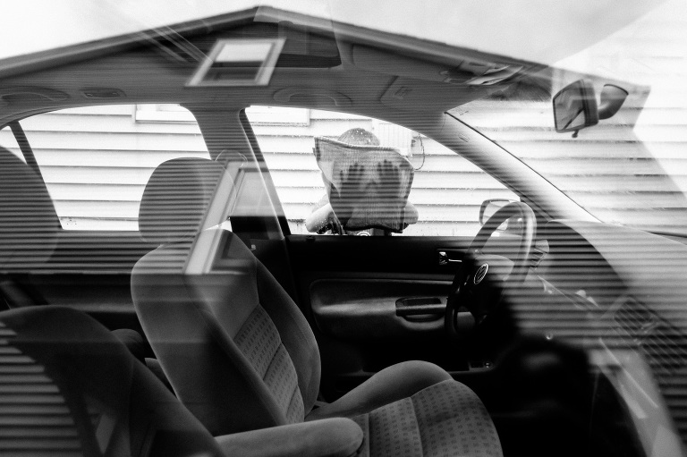 Young child washes window of car