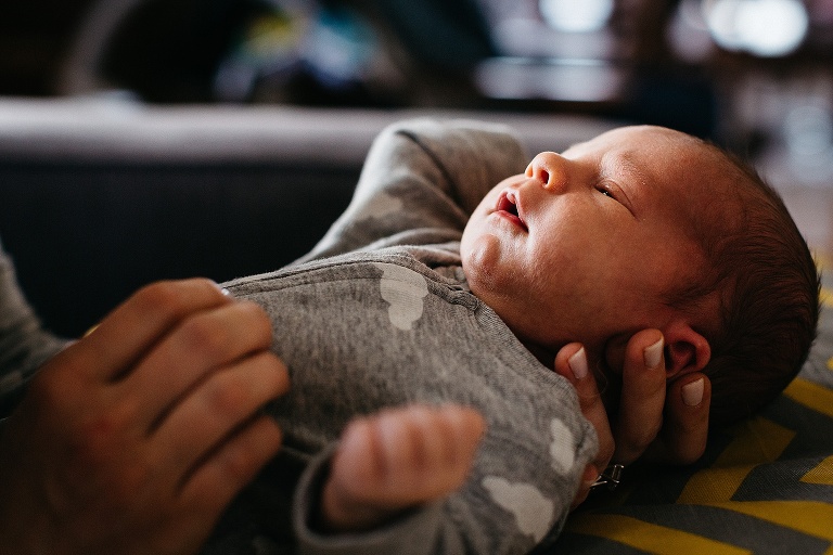 Mother holds sleepy newborn baby.