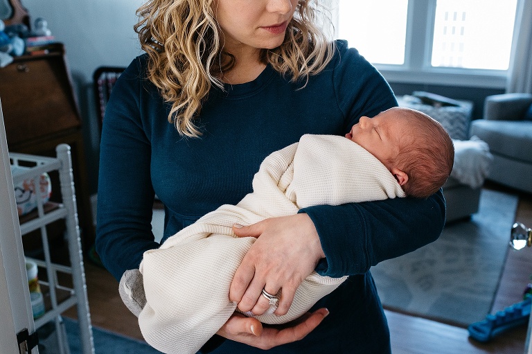 Mother cradles newborn baby in her arms.