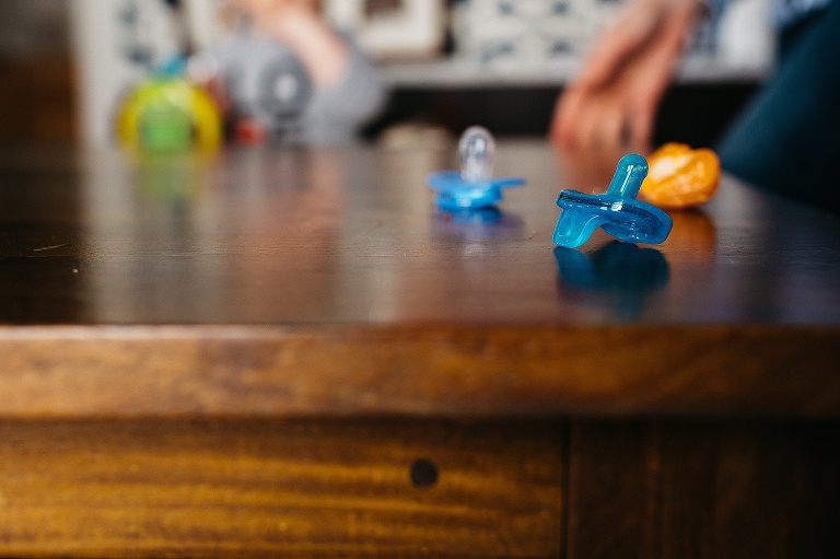 Pacifiers sitting on the wood dinner table.