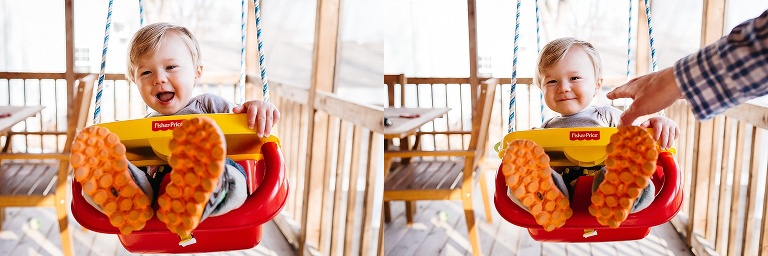 Father pushes baby boy in swing on the porch.