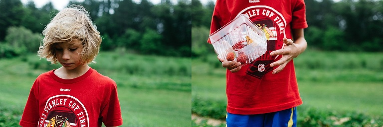 Boy holds onto clear carton filled with strawberry's