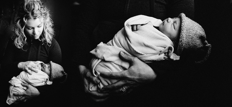 Black and white. Mother holds swaddled and sleeping newborn baby.