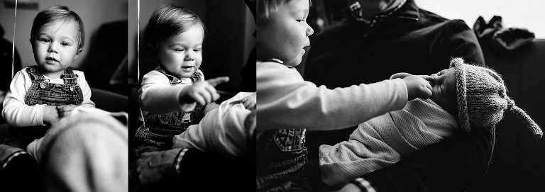 Black and white. Little kid looks at sleeping newborn baby.