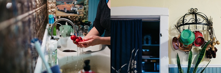 Woman in her kitchen washes fresh red cherry tomatoes. Three colanders hand from a pot rack on a kitchen wall.