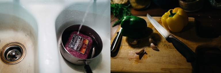 Ground beef in a cooking pot laying in a sink as water falls fills the pot. green and yellow peppers sit on a wood cutting board with a knife.