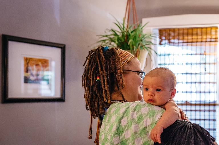 Mother holds baby boy looking over her shoulder.