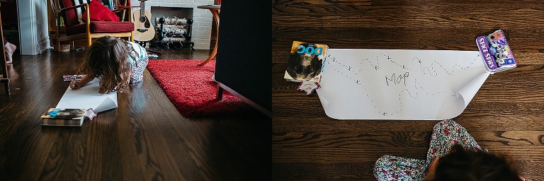 Young girl sits on wood floors making a treasure map.