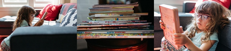 Young girl sits on the couch reading a stack of books.