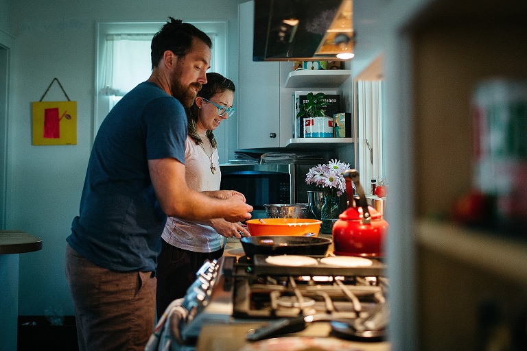 Mother and father make pancakes in the kitchen.