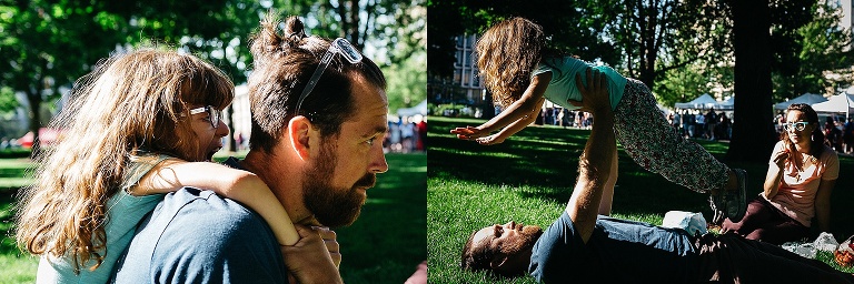 Dad plays with his daughter in the grass at a farmers market.