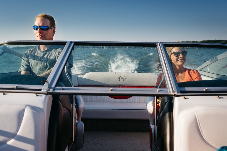 Man driving a speed boat, wife sitting next to him.