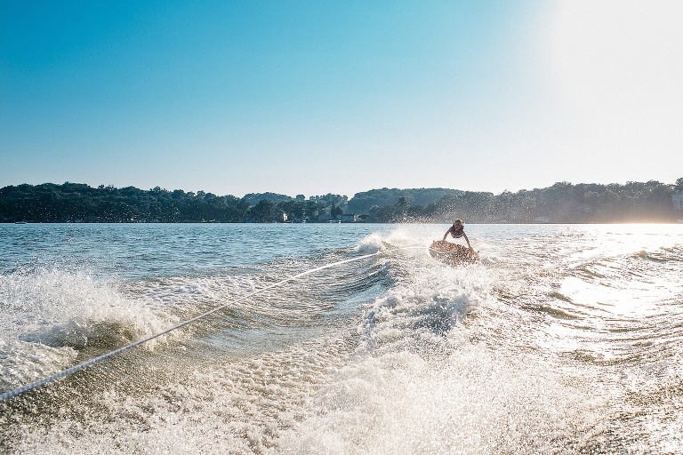 kid on a inter tube getting pulled by a motorboat.