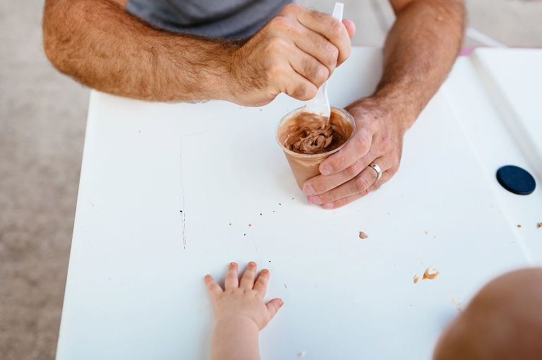 Dad scoops chocolate ice cream out of the cup.