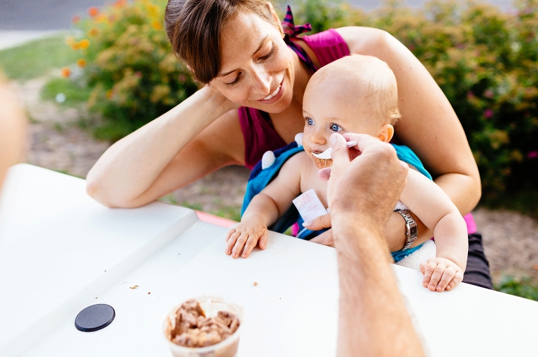 Mother watches as her husband feeds her son ice cream.